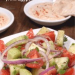 An Egyptian salad made with tomatoes cucumber and onions served with tahini and pita bread.