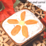 A bowl of creamy raita decorated with a flower made from carrot slices