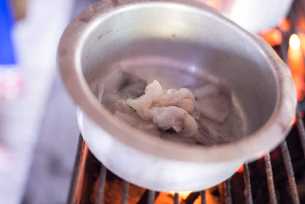 calamari in a pot cooking out the water to make it tender