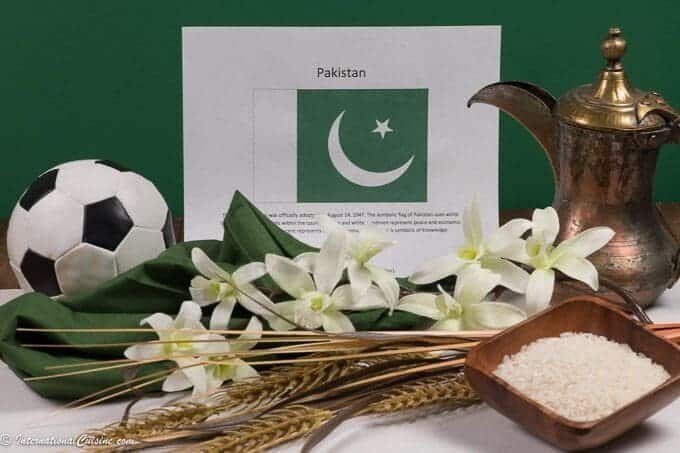 A picture of the flag of Pakistan with a soccer ball, rice and wheat along with jasmine.