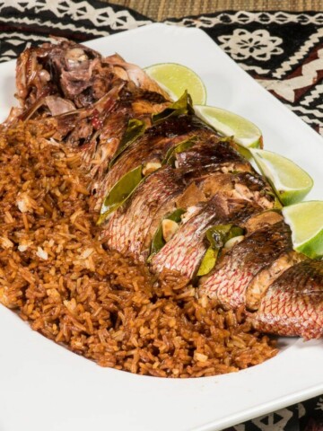 A snapper fish plated with rice and lime