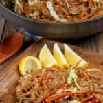 A plate of pancit noodles with pork and vegetables