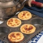 4 beautiful pais de nata custard tarts in a muffin pan.