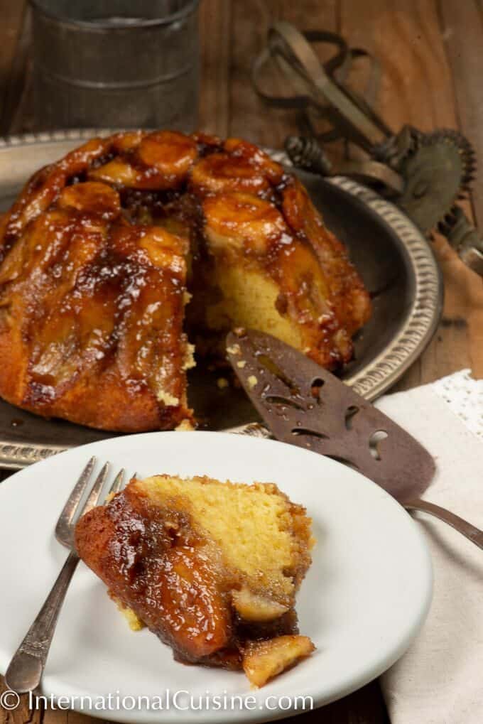 A cake smothered with caramel and bananas