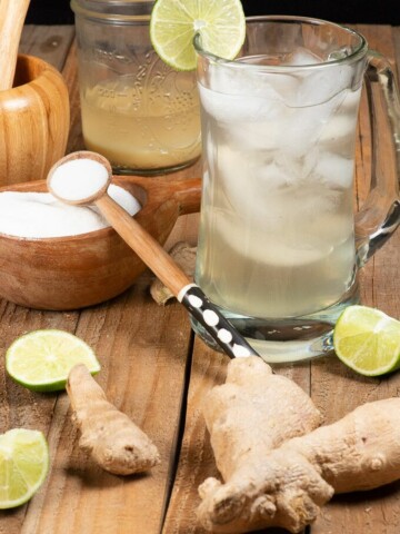 A glass of Sierra Leone Ginger beer surrounded by the ingredients.