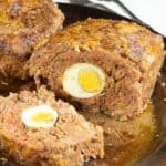 A meatloaf with hard boiled eggs in the middle.