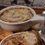 A bowl of French onion soup with a cheesy crouton