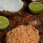 Una ciotola piena di pol sambol con cocco, lime, scalogno e peperoncini rossi come ingredienti.