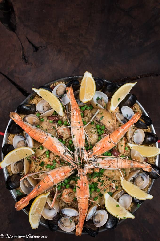 A pan full of paella rice topped with meats and seafood.