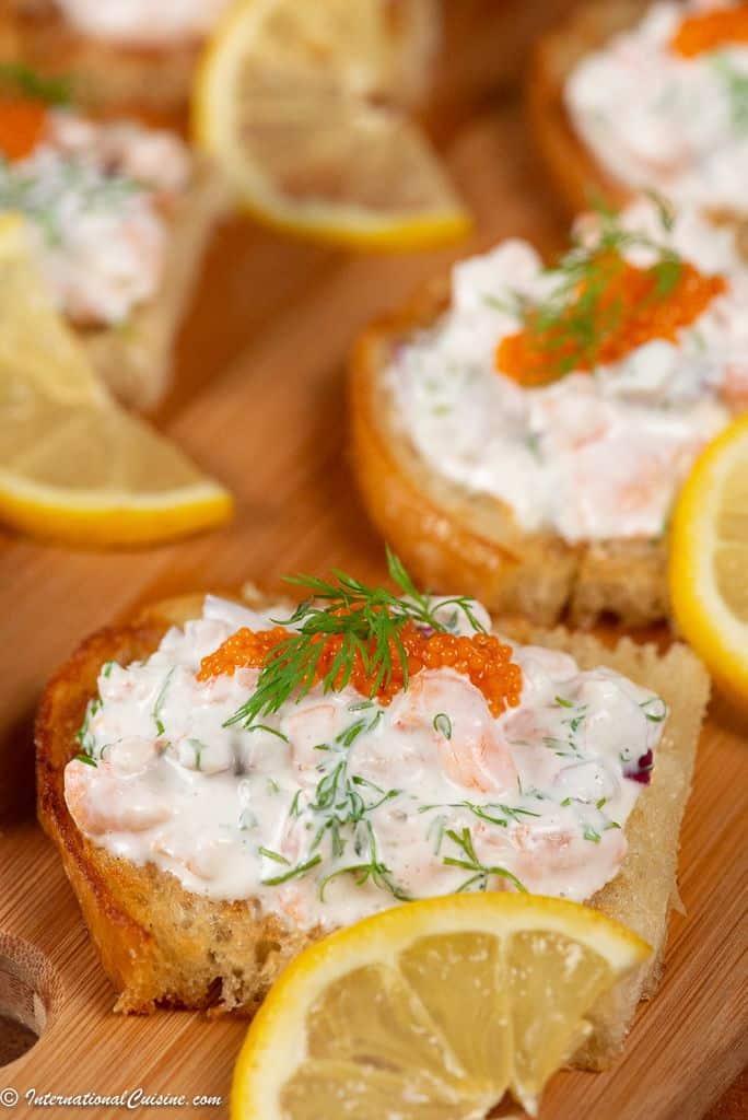 A plateful of Toast Skagan, shrimps in a mayonaise mixture topped with caviar, garnished with dill and a thin slice of lemon.