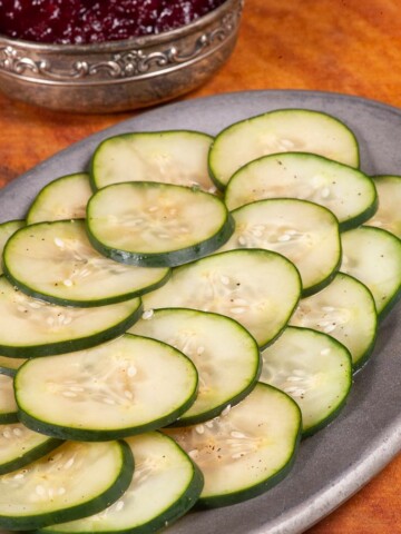 a plateful of thinly sliced pickled cucumbers called pressgurka in Sweden.