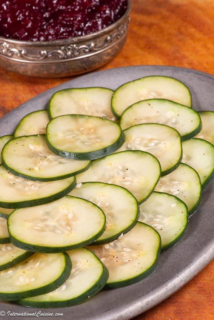 a plateful of thinly sliced pickled cucumbers called pressgurka in Sweden. 