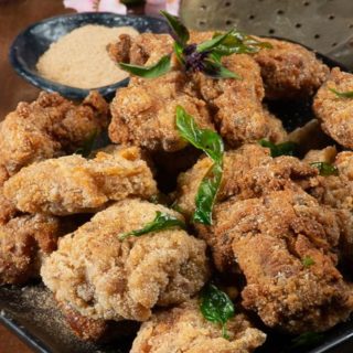 A plateful of Taiwanese popcorn chicken with bits of fried basil on top