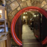 A picture of a head hoop of a large wine barrel which serves as a doorway into the restaurant