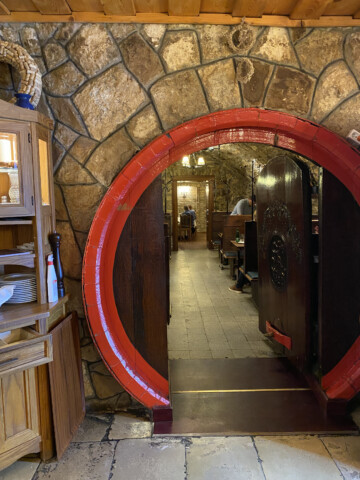 A picture of a head hoop of a large wine barrel which serves as a doorway into the restaurant