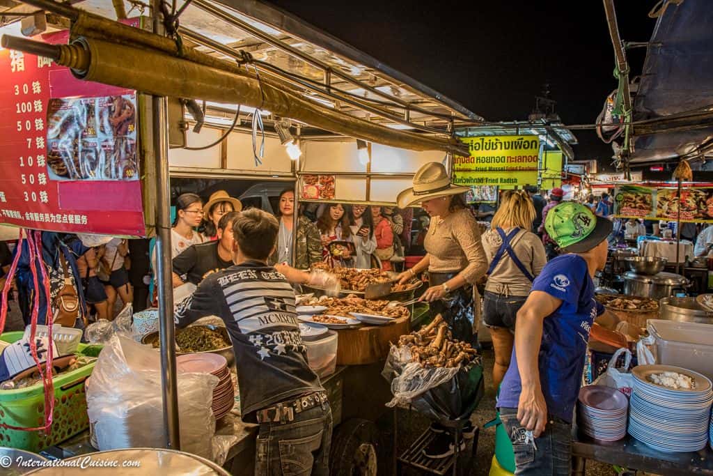 Cowboy hat lady making her famous pork knuckle dish at night market Chiang Mai.