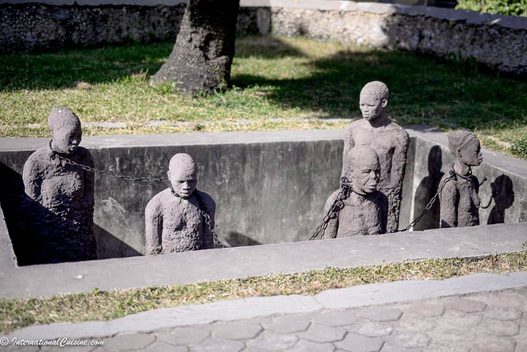 Statues of black slaves chained together in a pit