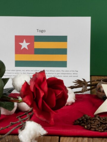 a photo that shows symbols of Togo their flag, a red rose, cotton and coffee beans