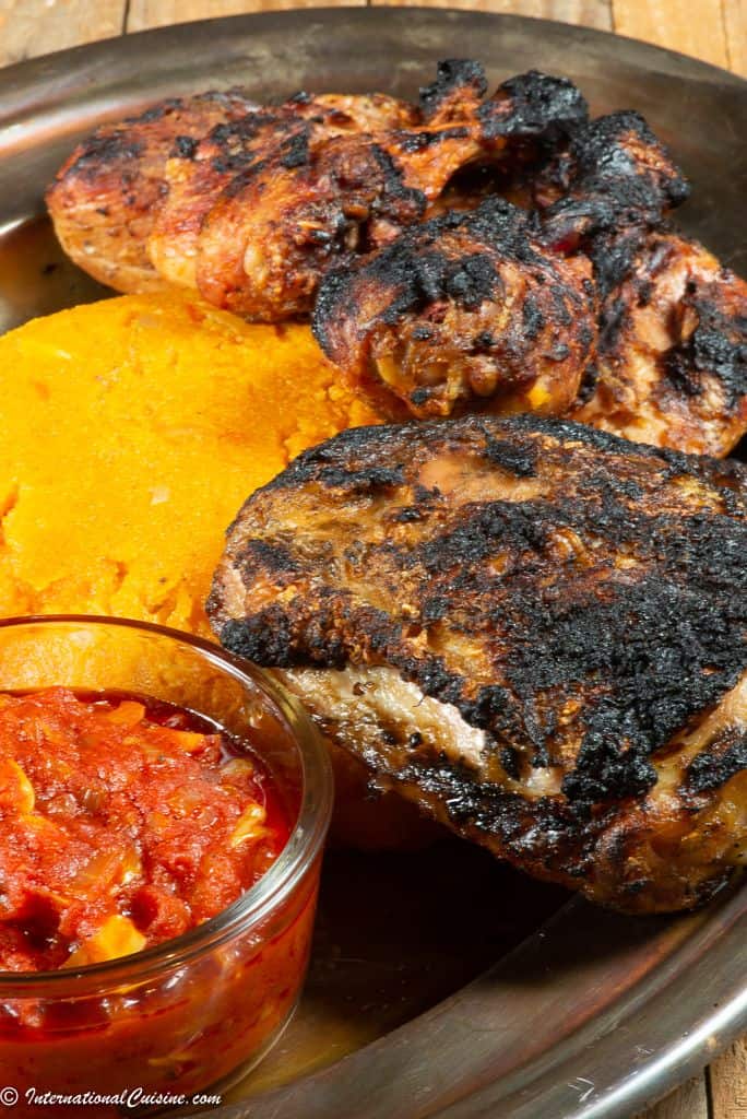 A plateful of Togolese grilled chicken served with djenkoume, a tomato cornmeal