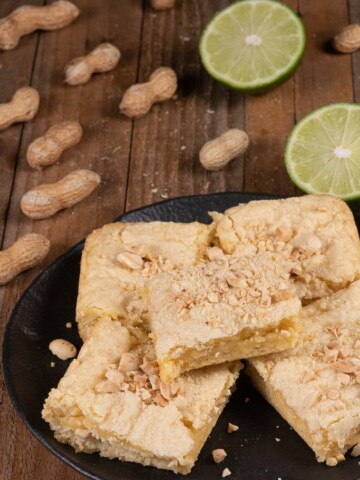 pieces of West African Lime cake called Keke cut into squares and topped with peanuts