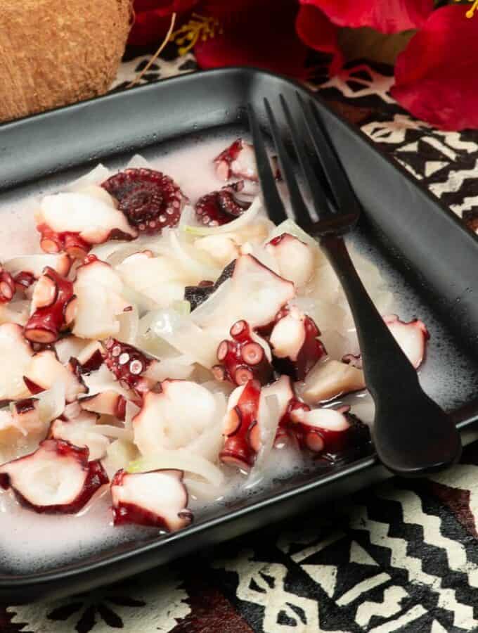 a dish full of octopus in a creamy coconut and onion sauce.