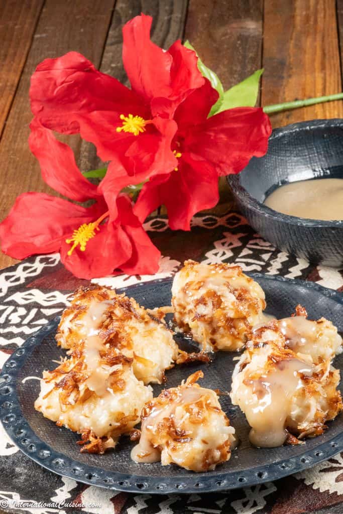 A plate full of Tongan banana dumplings served with a caramel coconut sauce.
