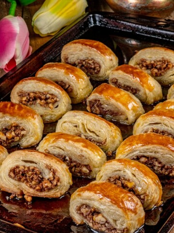 a pan full of cooked samsa oozing with nuts.