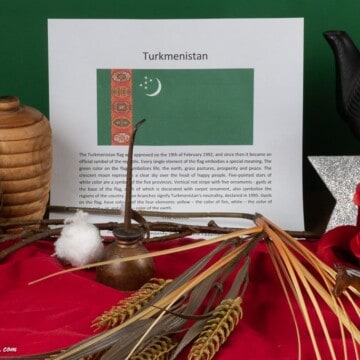 Symbols of Turkmenistan including wheat, a rose, cotton and a tea pot.