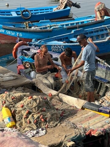 Fisherman in a wooden boat at the Punic Port in Carthage, Tunisia