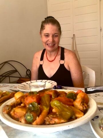 Jiji seated behind a traditional meal during a home cooking experience in Tunis.