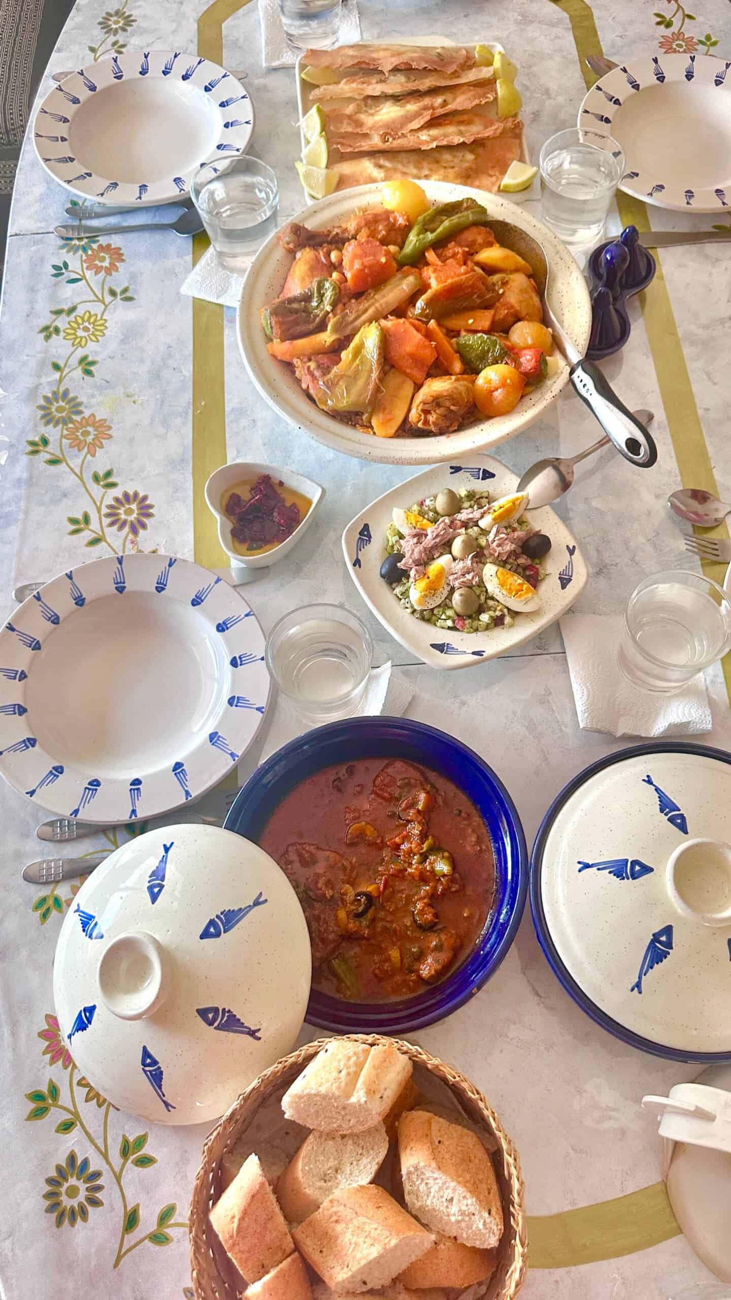 Tunisian meal of Brik, dwindle, Kabkabou, and Tunisian salad, served around Jiji's table.