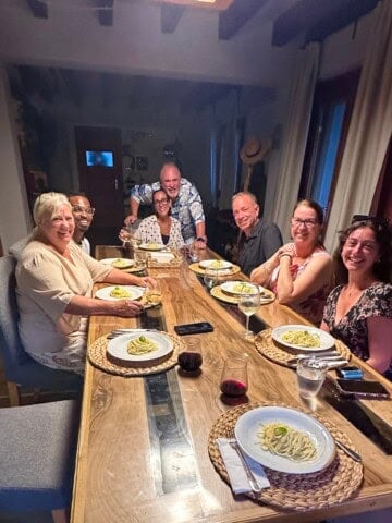 Friends gathered around a dining room table in Sicily