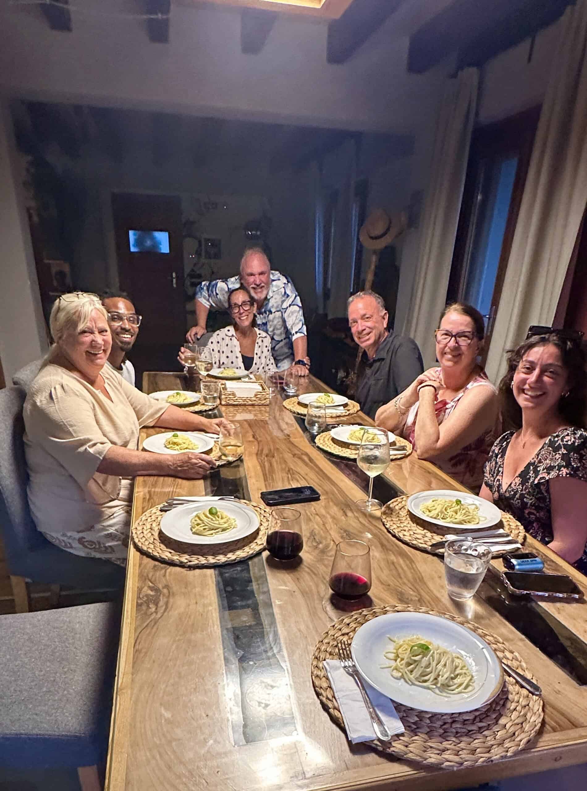 Friends gathered around a dining room table in Sicily