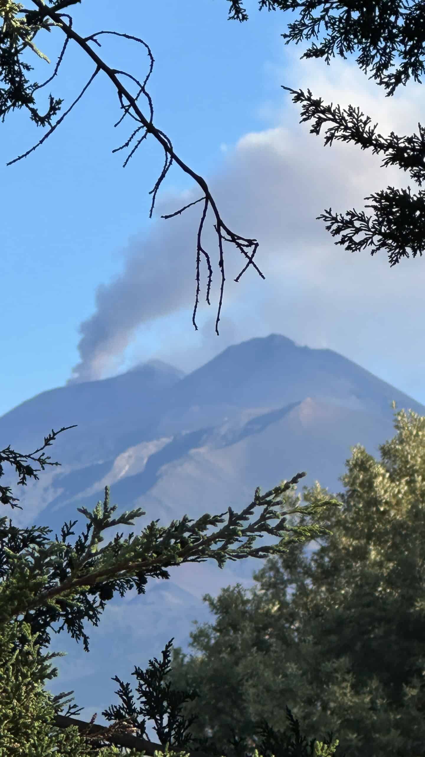 Mount Etna with black smoke coming out of a vent.